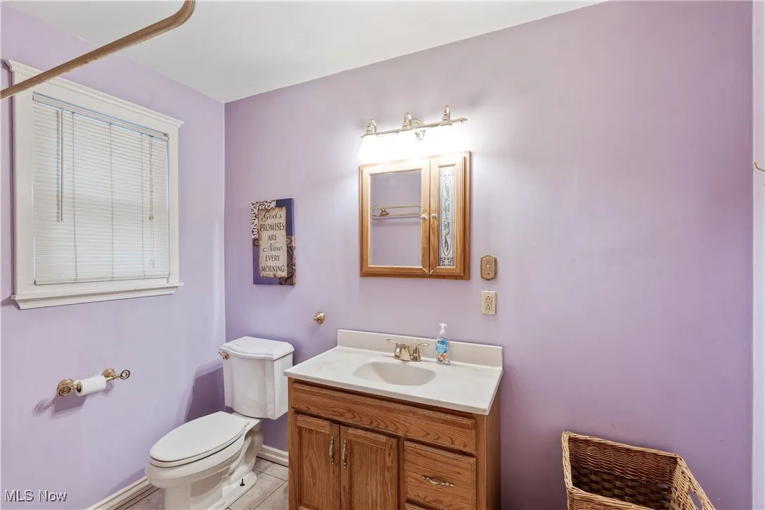 Half bathroom with light tile patterned floors and vanity