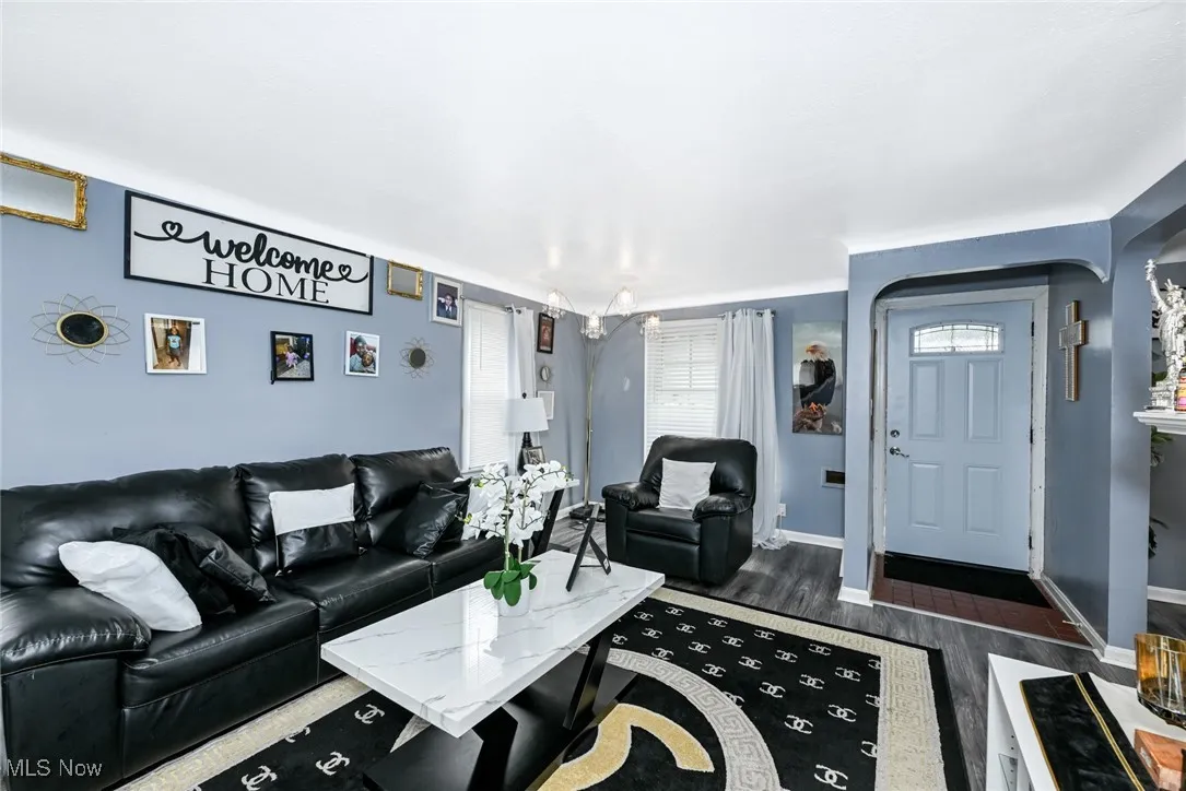 Living room with dark wood-type flooring and baseboards