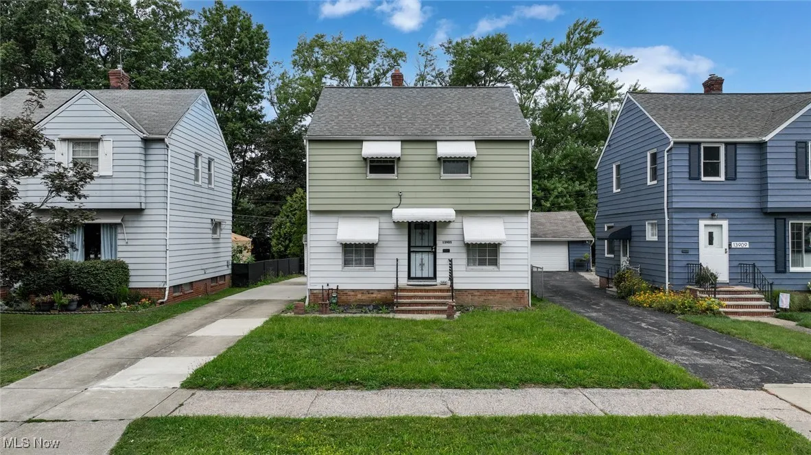 Colonial-style house with a chimney, a front yard, and roof with shingles