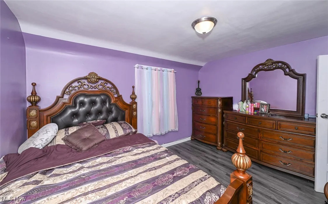 Bedroom with dark wood-type flooring and baseboards