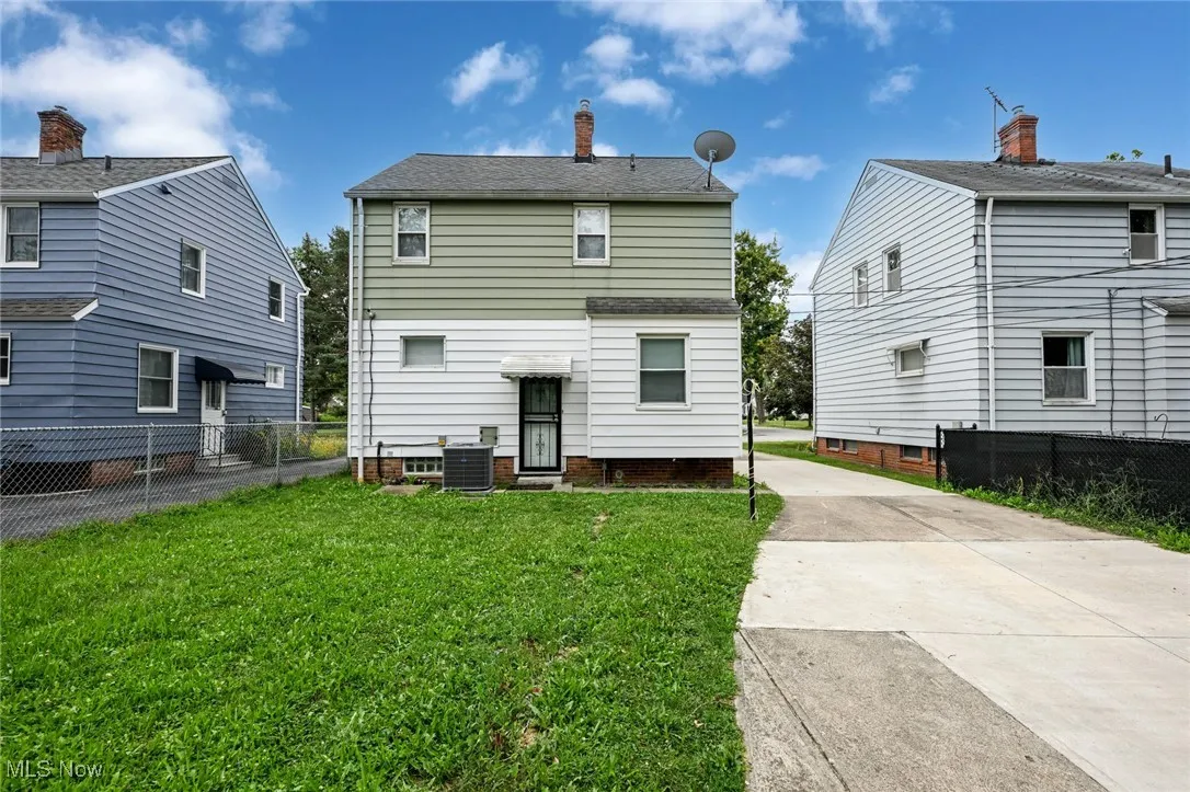 Rear view of property featuring driveway and a chimney
