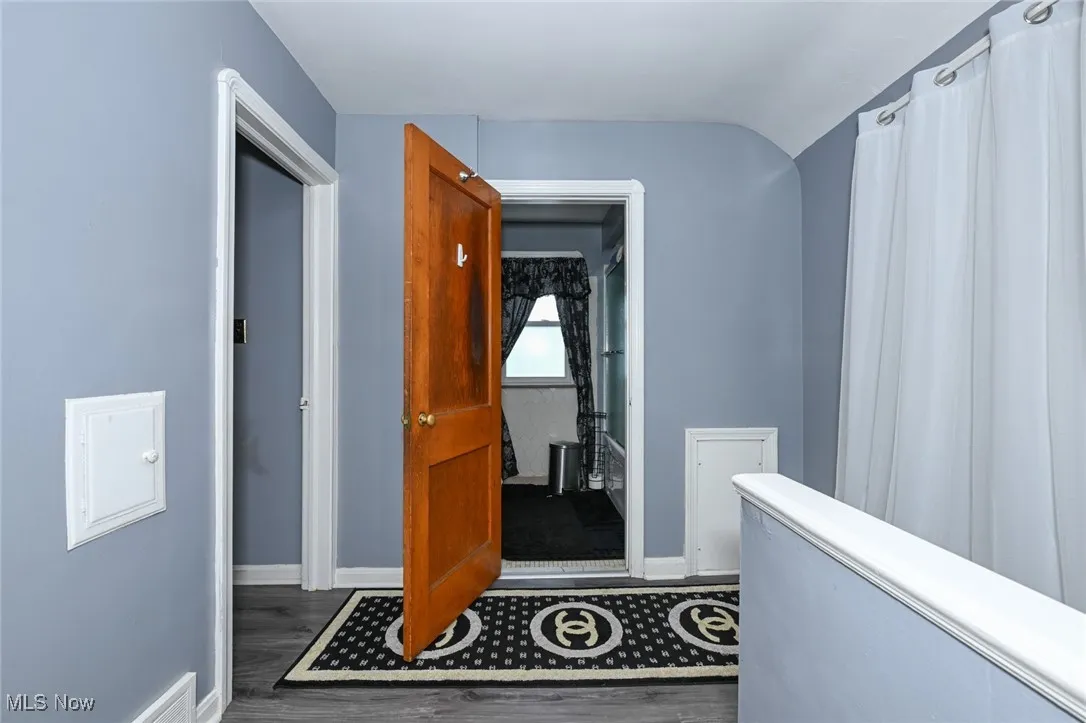 Hall with dark wood-type flooring and an upstairs landing