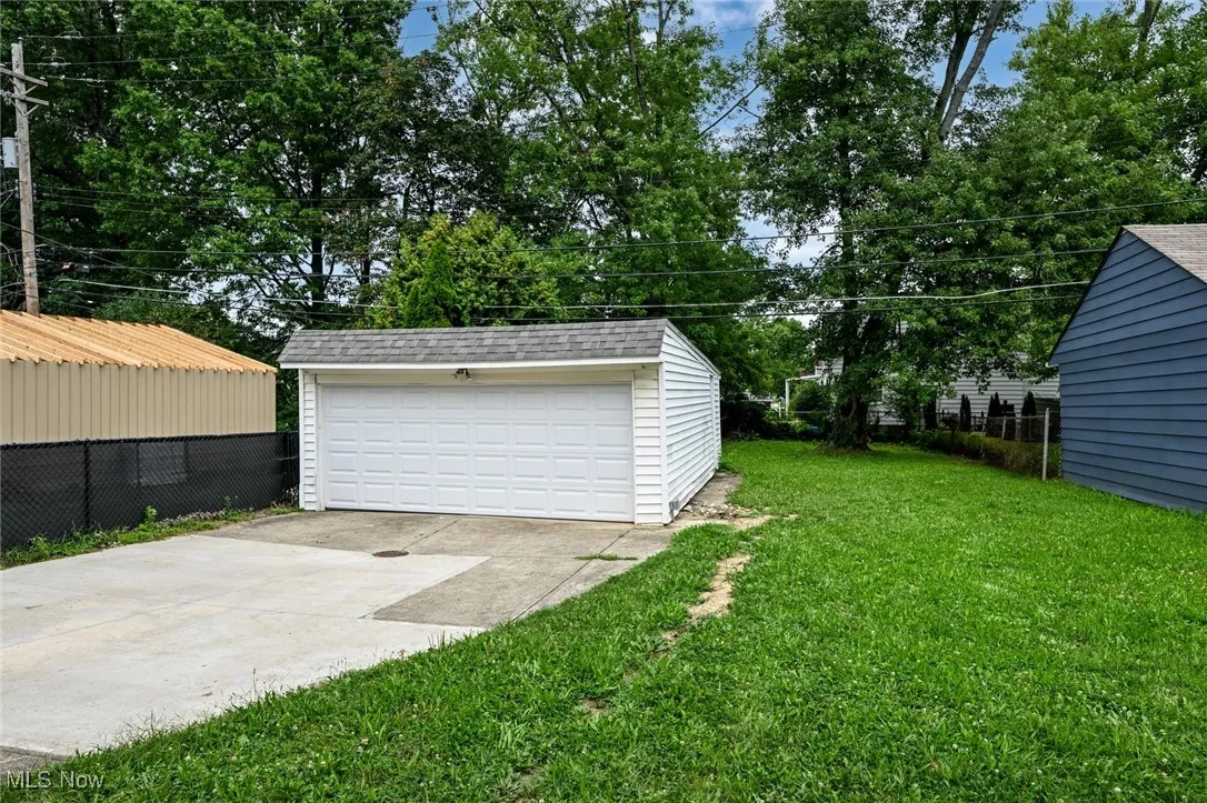 Detached garage with view of scattered trees