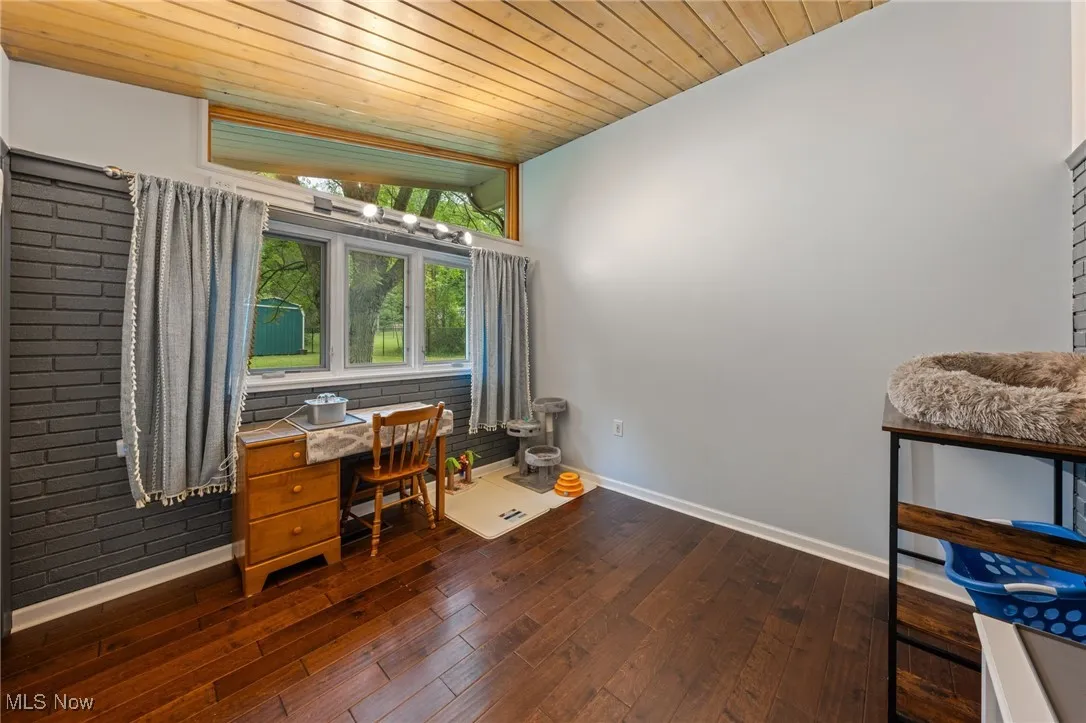 Home office with wooden ceiling and dark wood-style floors