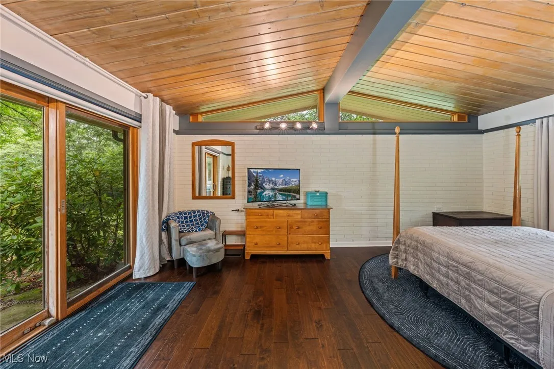 Bedroom with dark wood finished floors and wood ceiling