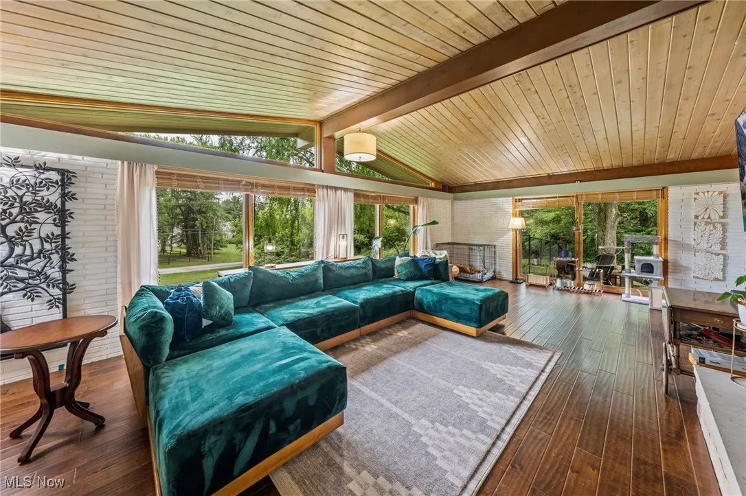 Living room featuring dark wood-type flooring, plenty of natural light, and wood ceiling