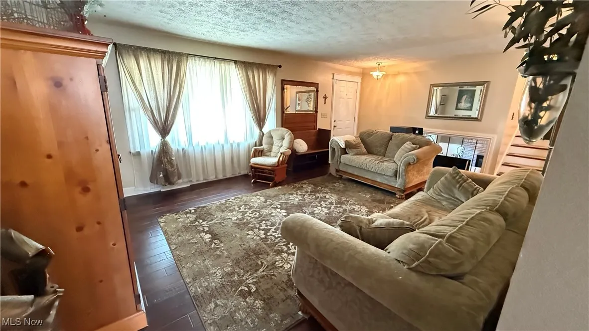 The living room area features engineered hardwood floors and a large picture window with tons of natural light