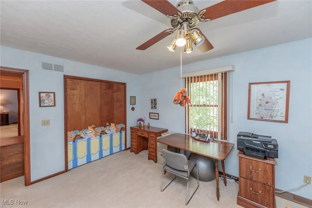 Bedroom featuring light colored carpet, ceiling fan, and a textured ceiling