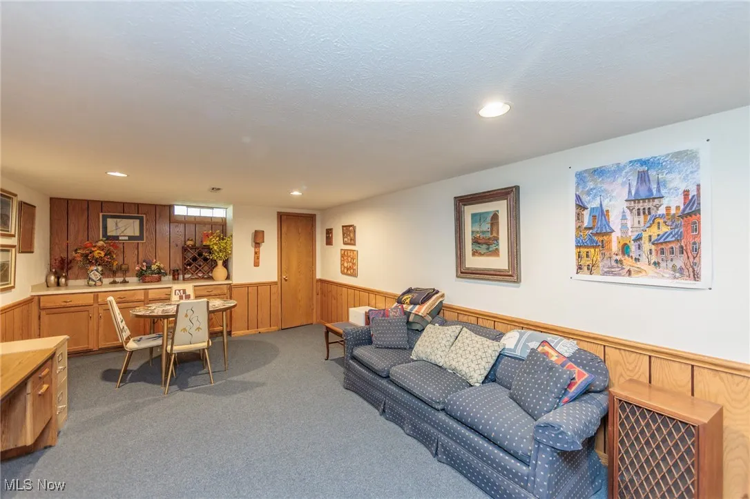 Recreation room with wood walls, a wainscoted wall, light carpet, and recessed lighting