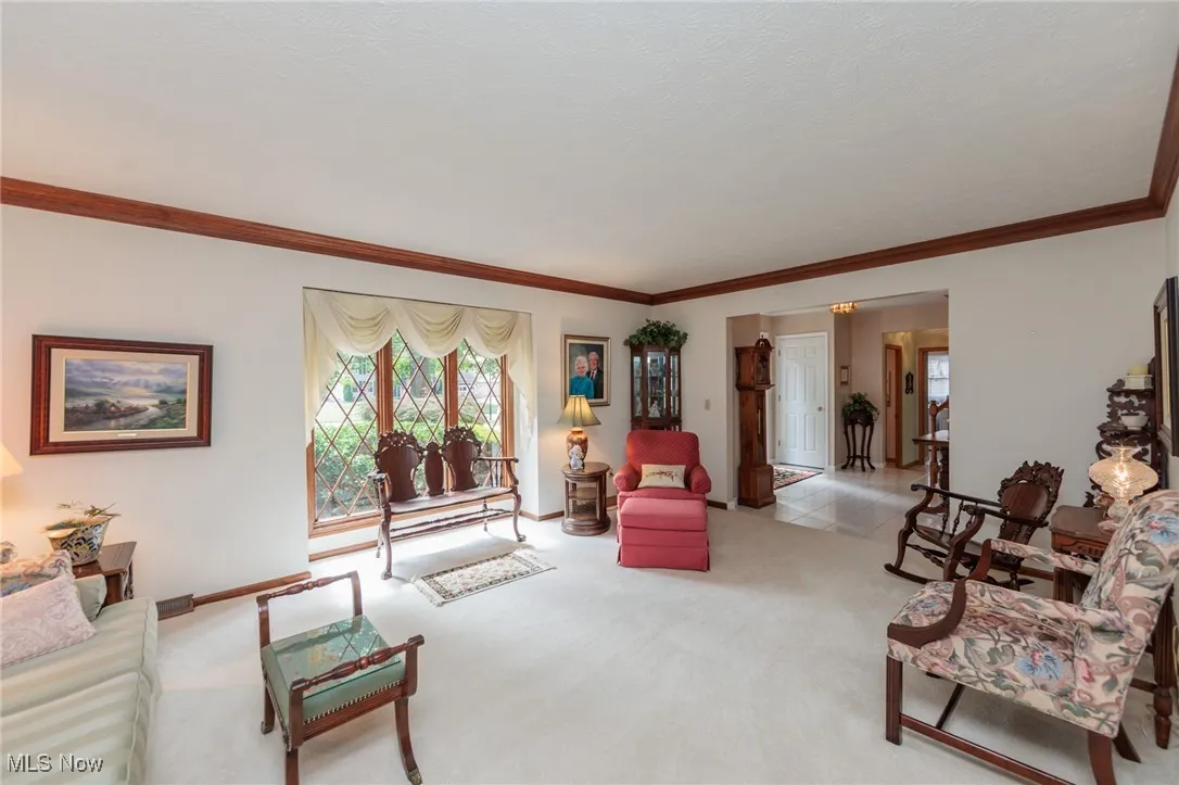 Living room with ornamental molding and carpet floors