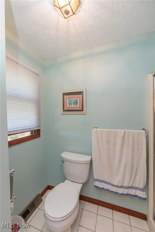 Full bathroom featuring tile patterned floors and a textured ceiling