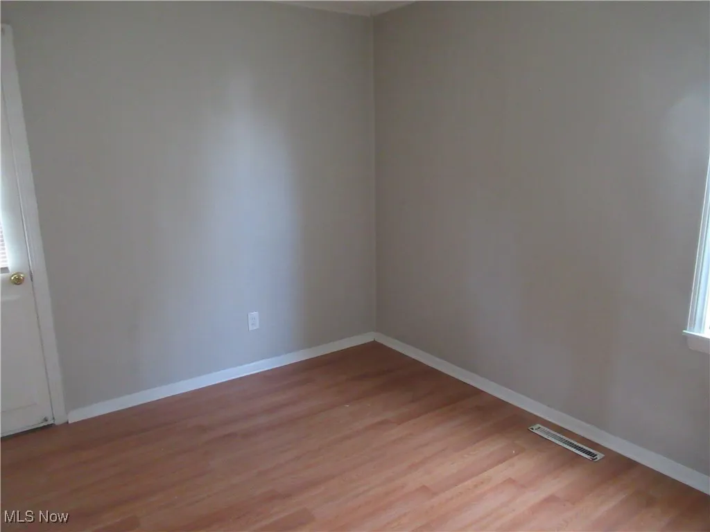 Unfurnished room with baseboards and light wood-style flooring