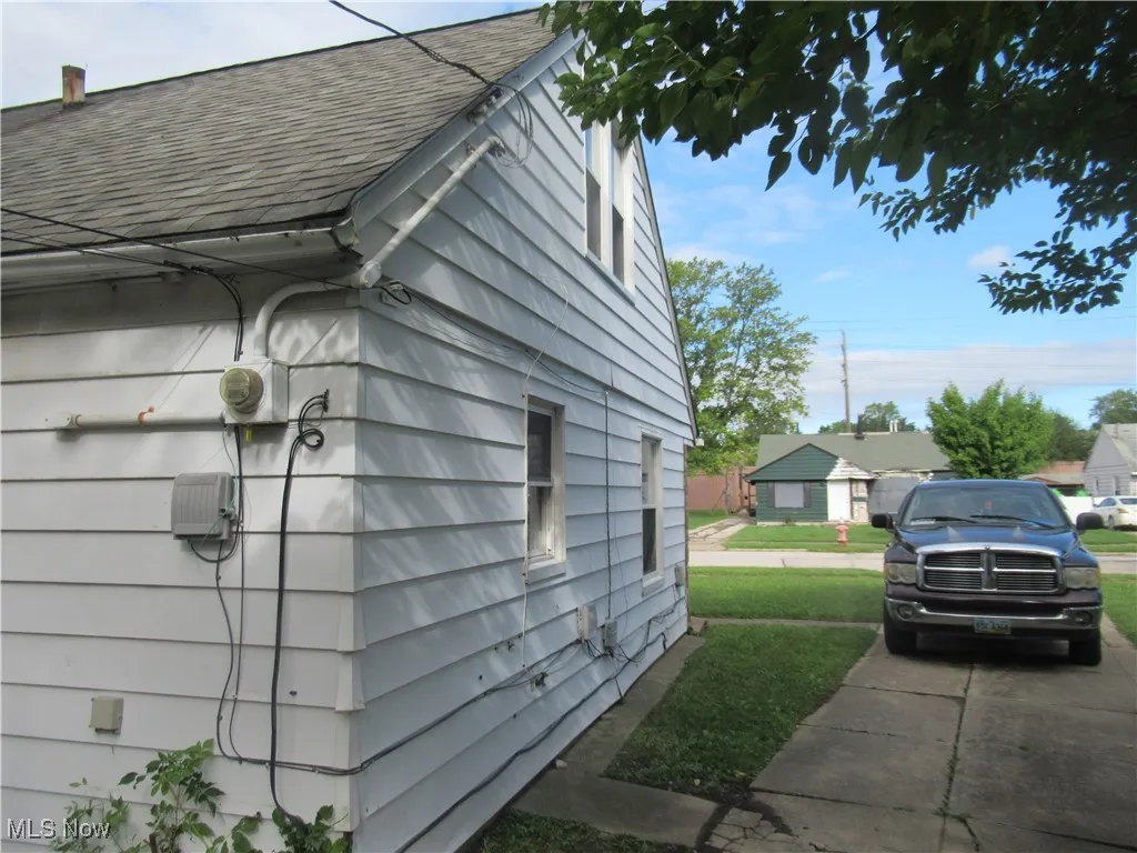 View of side of property featuring a shingled roof