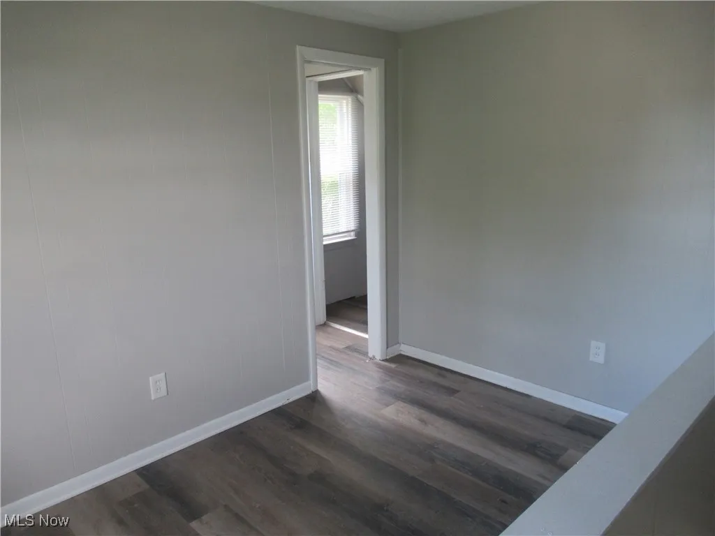 Unfurnished room featuring dark wood finished floors