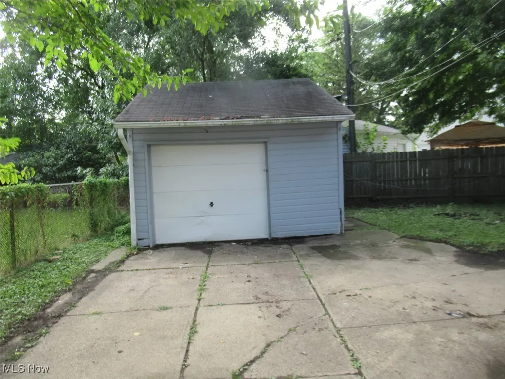 Detached garage featuring concrete driveway