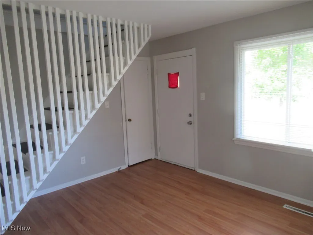 Entryway with light wood finished floors and stairway