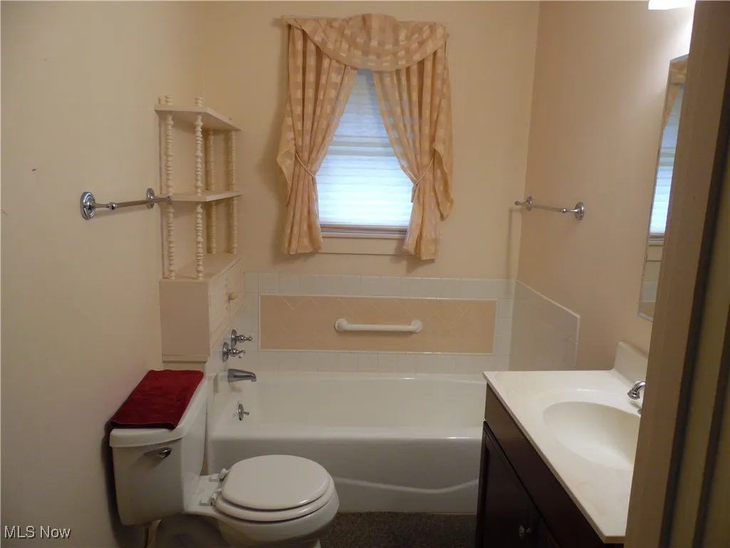 Full bath featuring a bath, vanity, and healthy amount of natural light