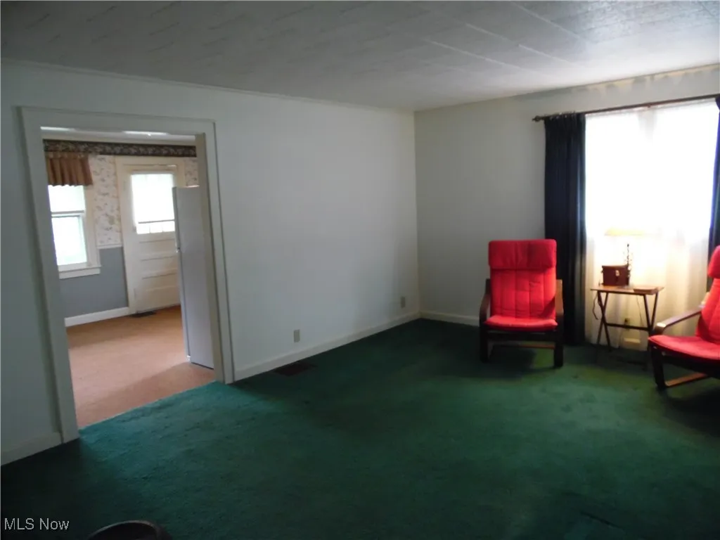 Unfurnished room with plenty of natural light and dark carpet