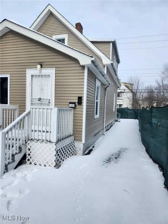 Snow covered property featuring a wooden deck and a chimney