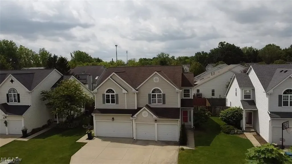 Traditional-style house featuring a garage, driveway, a front yard, and a residential view