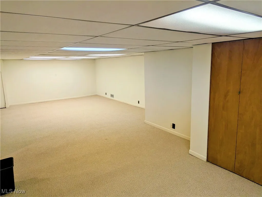 Finished below grade area featuring carpet and a drop ceiling