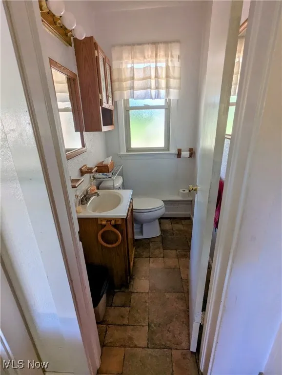 Half bath featuring vanity and stone tile floors