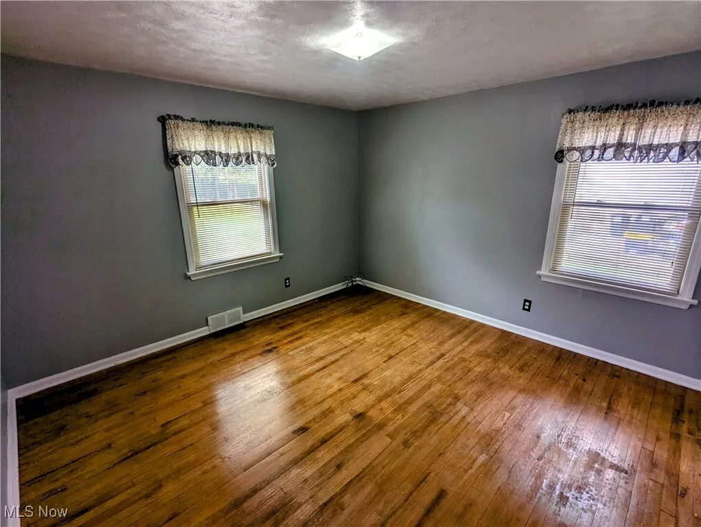 Another view of the first floor Bedroom featuring hardwood flooring, a textured ceiling, and a closet