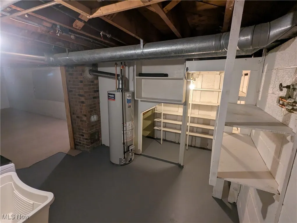 Pantry shelves under stairs and water heater in basement laundry room