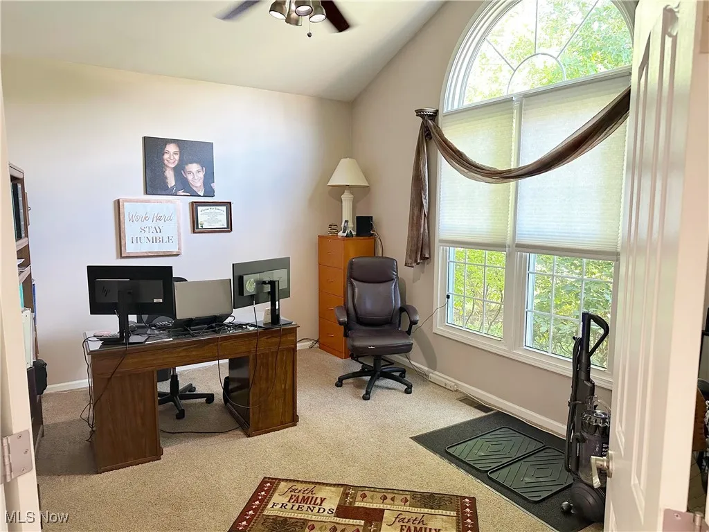 Office area with vaulted ceiling, carpet floors, and ceiling fan