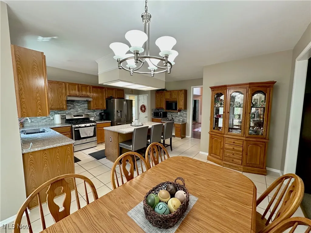 Dining area with light tile patterned floors and a chandelier