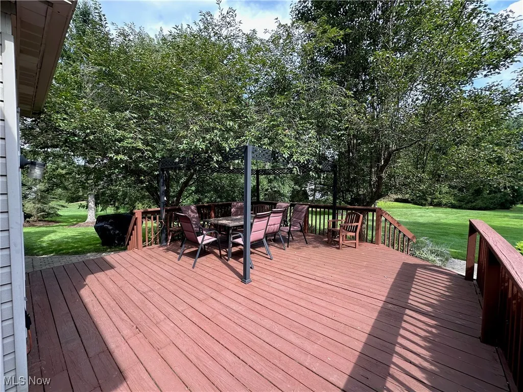 Deck with a lawn and outdoor dining space