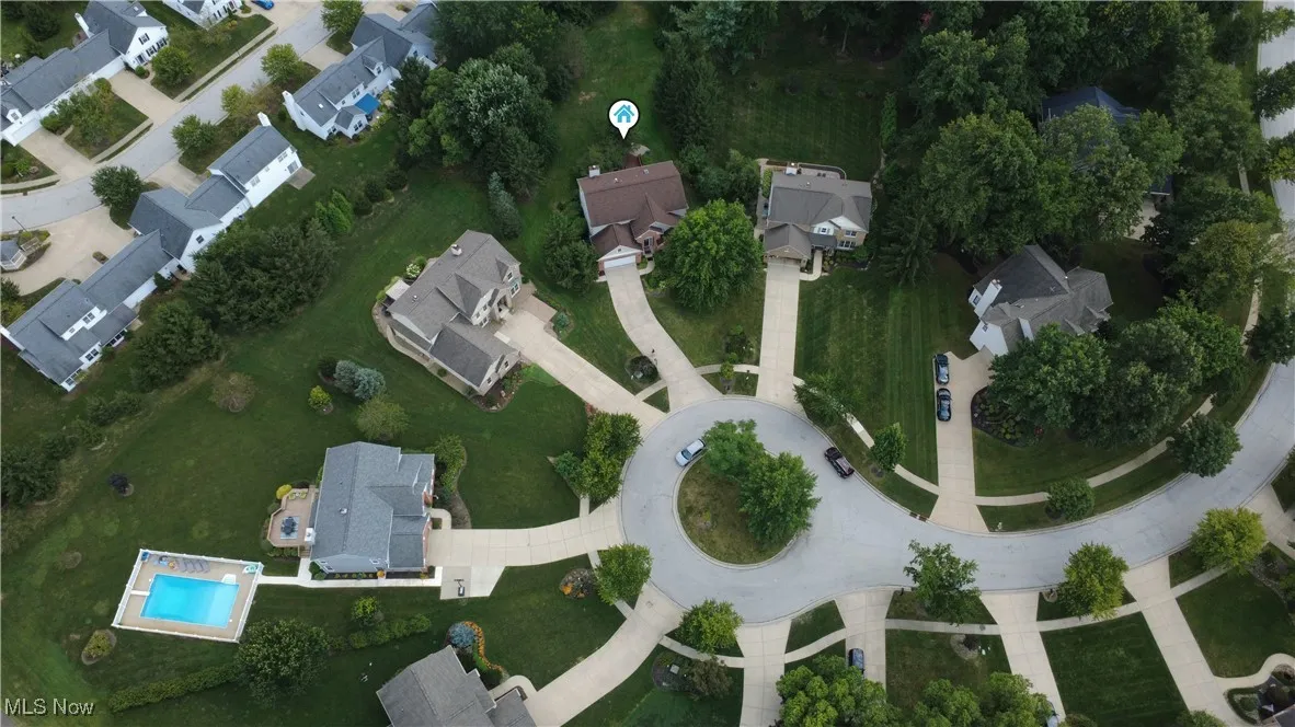 Aerial overview of property's location with nearby suburban area and a pool area
