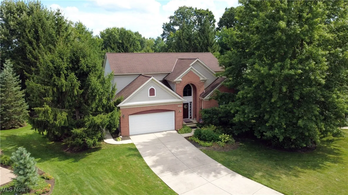 Colonial home featuring concrete driveway, a garage, and a front yard