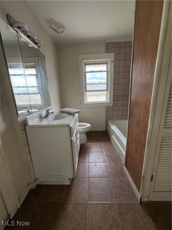 Bathroom with vanity and dark tile patterned floors