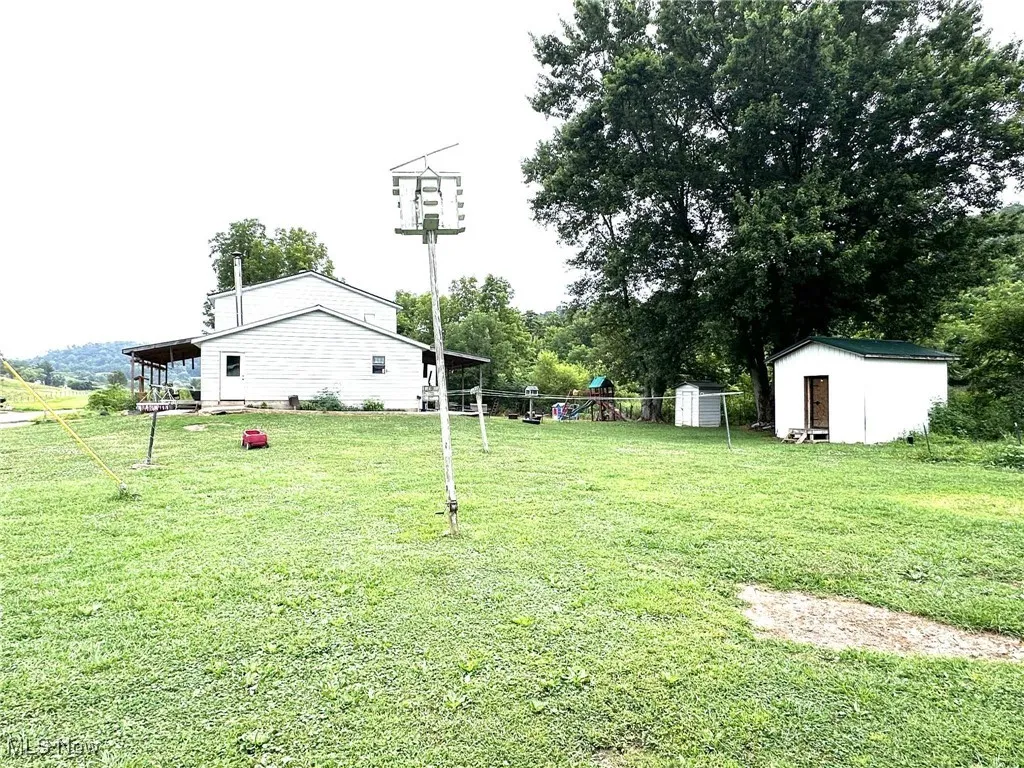 View of green lawn featuring a shed