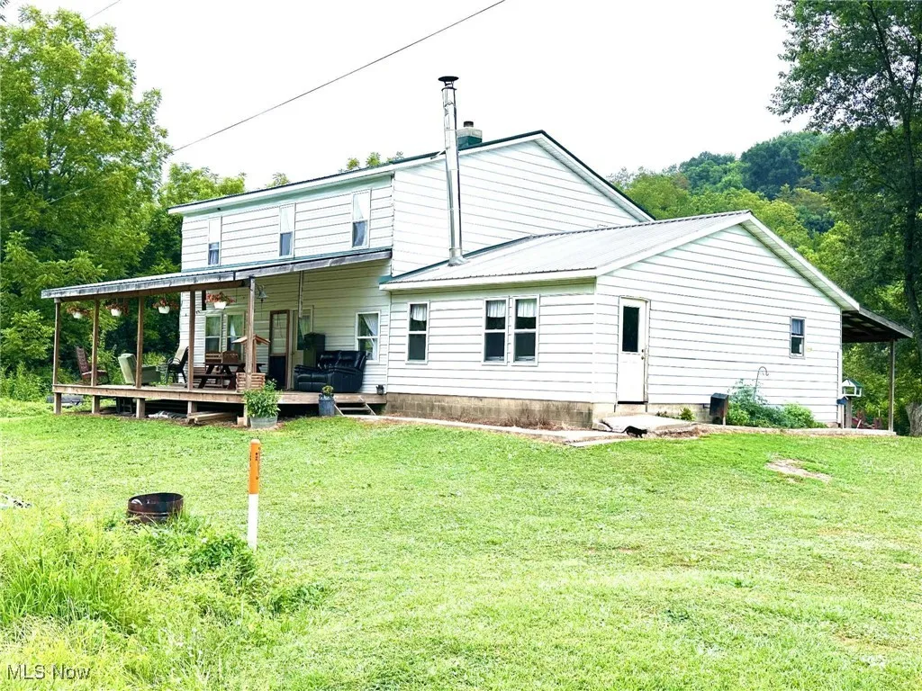 Back of property featuring a yard and a metal roof