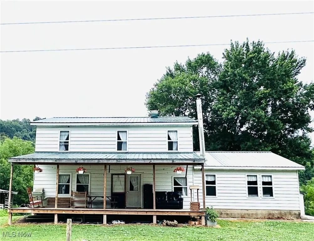 View of front of property with a metal roof, a front lawn, and a porch