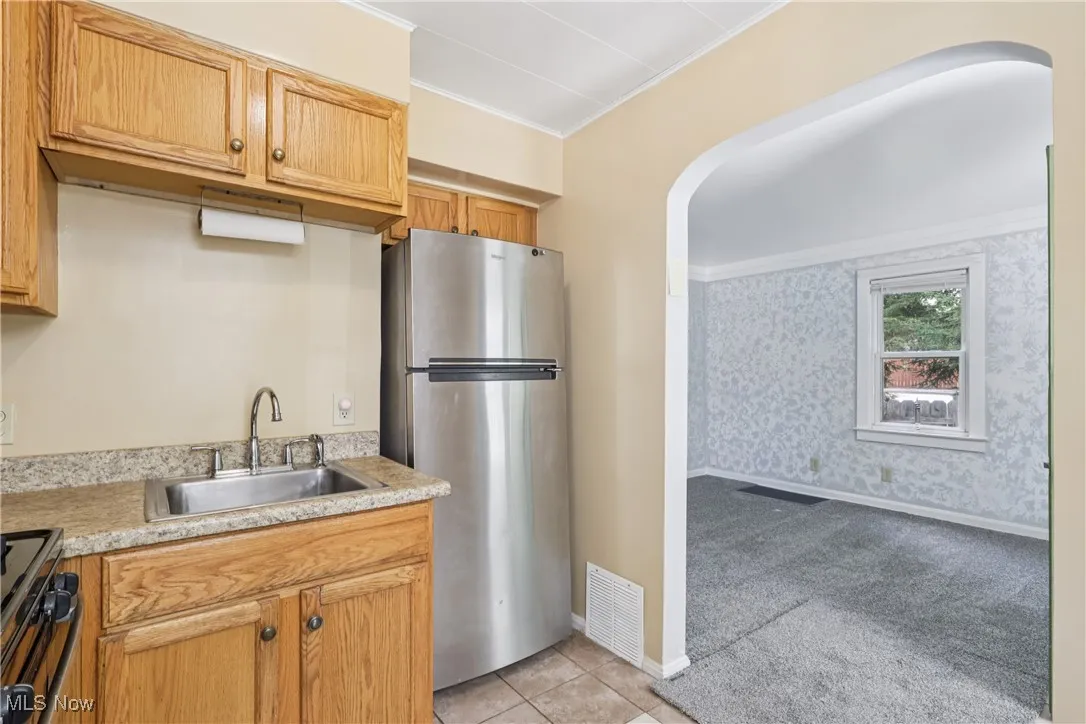 Kitchen with sink, stove, regriferator and tile flooring