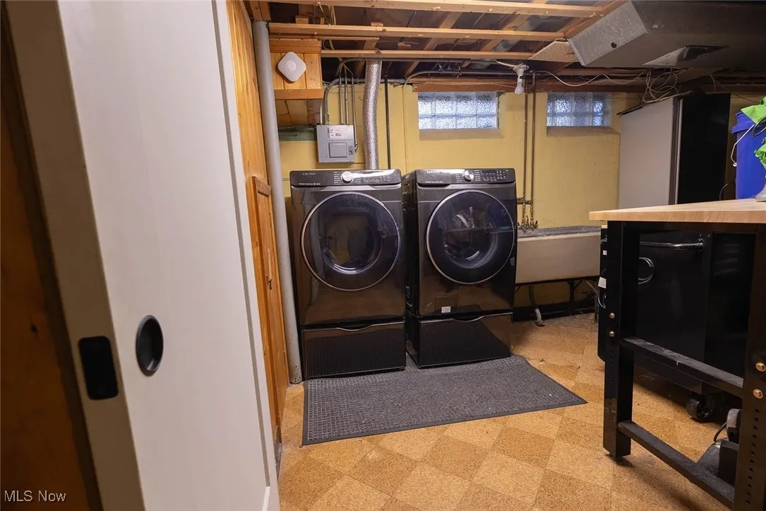 Laundry room with light floors and separate washer and dryer