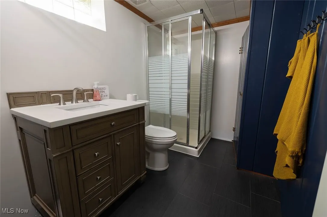 Bathroom with vanity, a shower stall, and ornamental molding