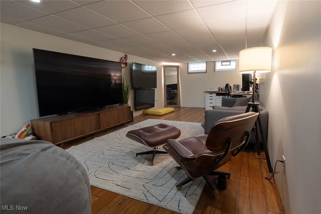 Living area featuring hardwood / wood-style flooring, a drop ceiling, and an office area