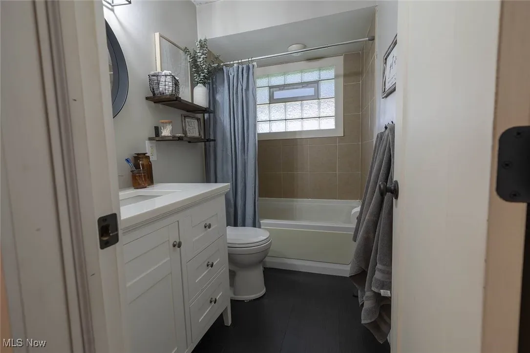 Bathroom featuring shower / bathtub combination with curtain and vanity