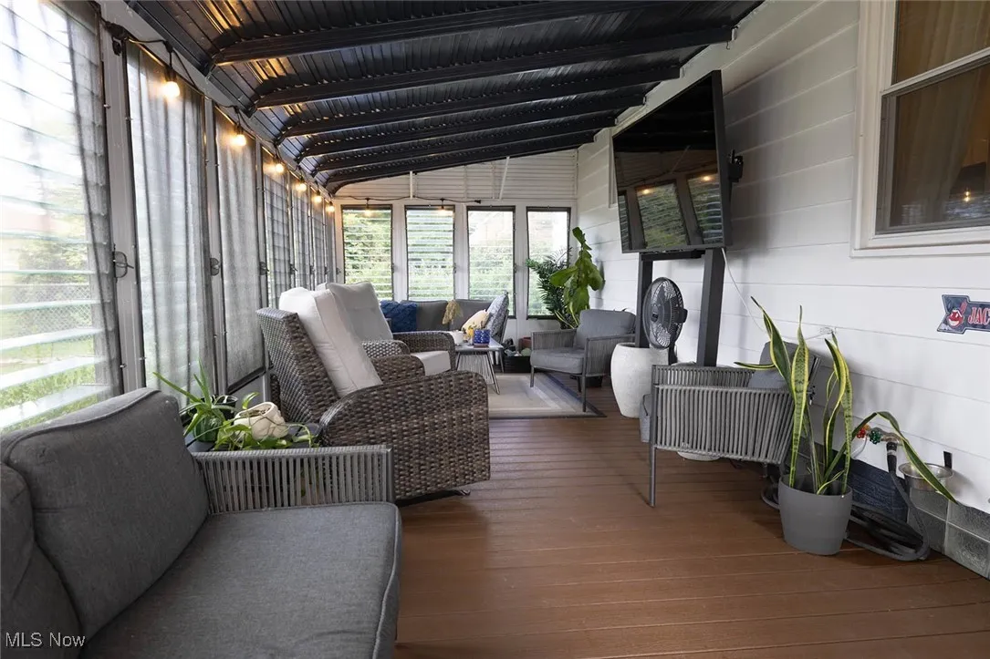 Sunroom featuring an outdoor living space, vaulted ceiling, hardwood / wood-style flooring, and a deck