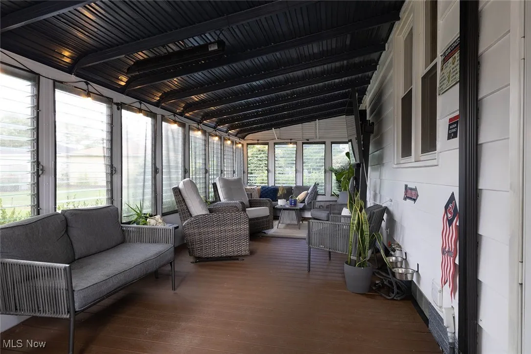 Sunroom with outdoor lounge area, lofted ceiling, and a deck
