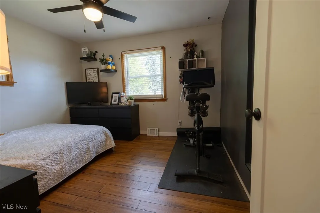 Bedroom with hardwood / wood-style floors and a ceiling fan