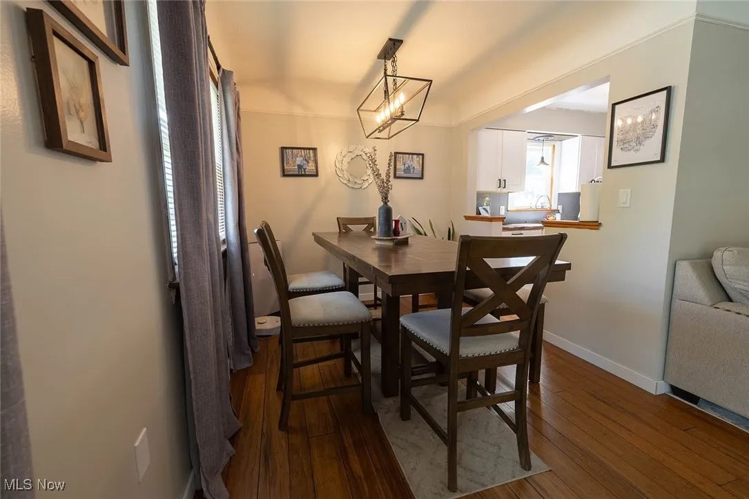 Dining room with dark wood-style floors and baseboards