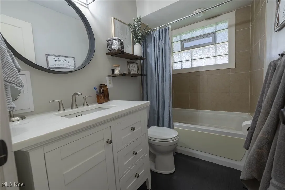 Bathroom featuring shower / tub combo with curtain and vanity