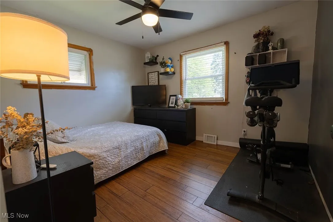 Bedroom with dark wood-style flooring and a ceiling fan