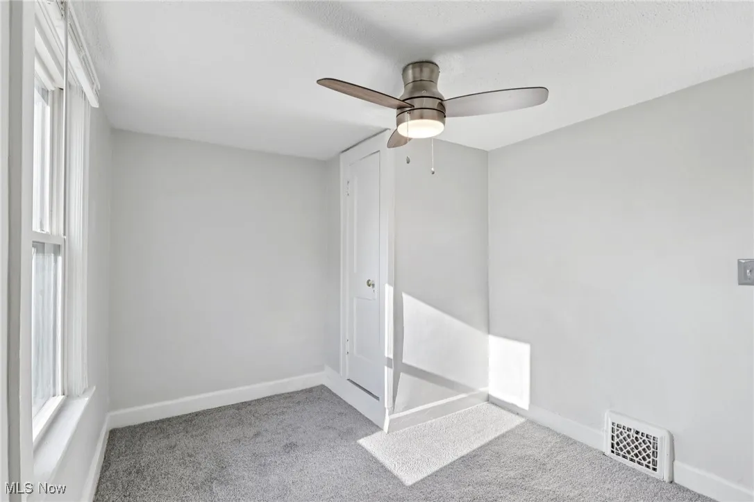 Unfurnished room featuring light colored carpet and a ceiling fan