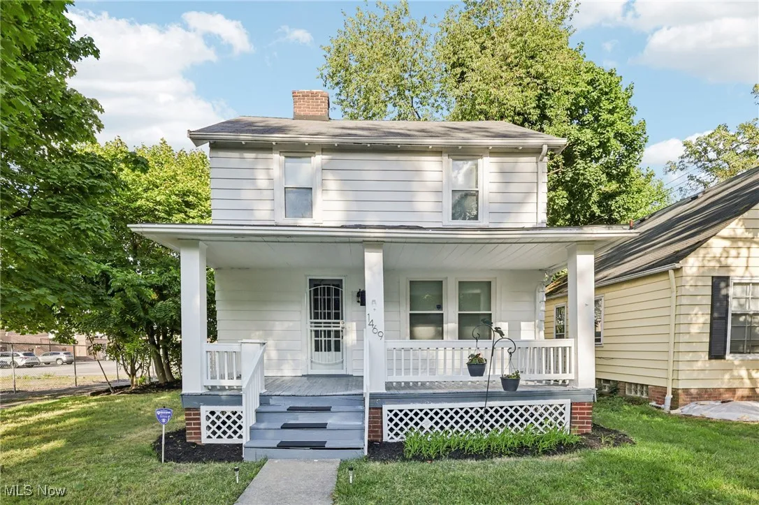 Traditional style home featuring a front lawn, a porch, and a chimney